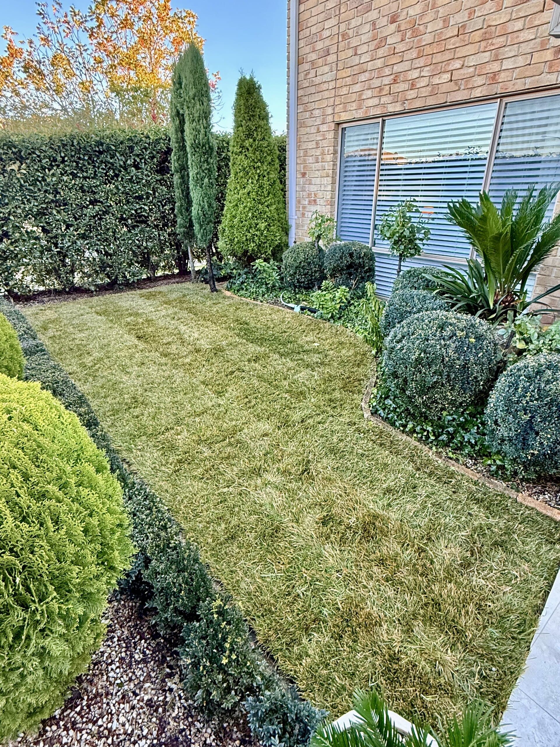 Neatly mown lawn beside a curved brick garden edge