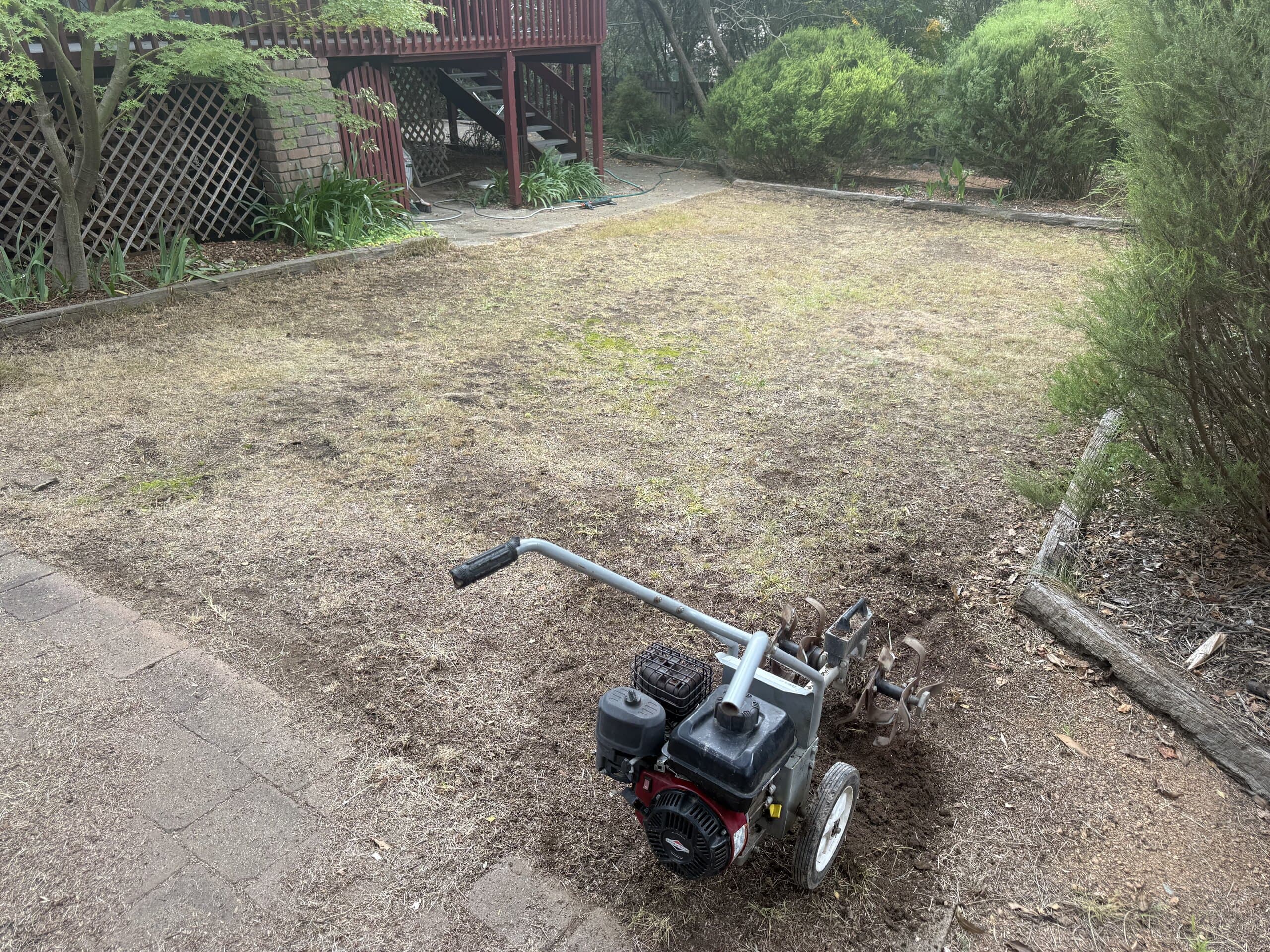 Rotary tiller standing on prepared backyard soil