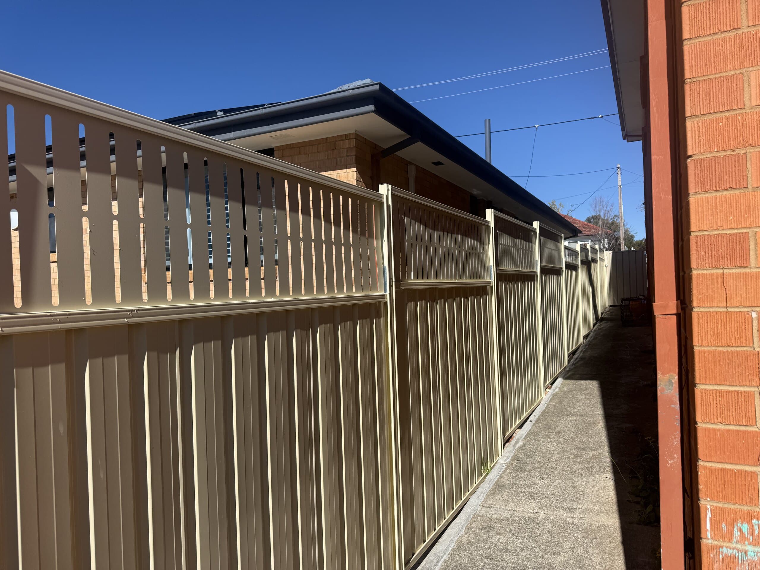 New metal boundary fence beside a concrete path
